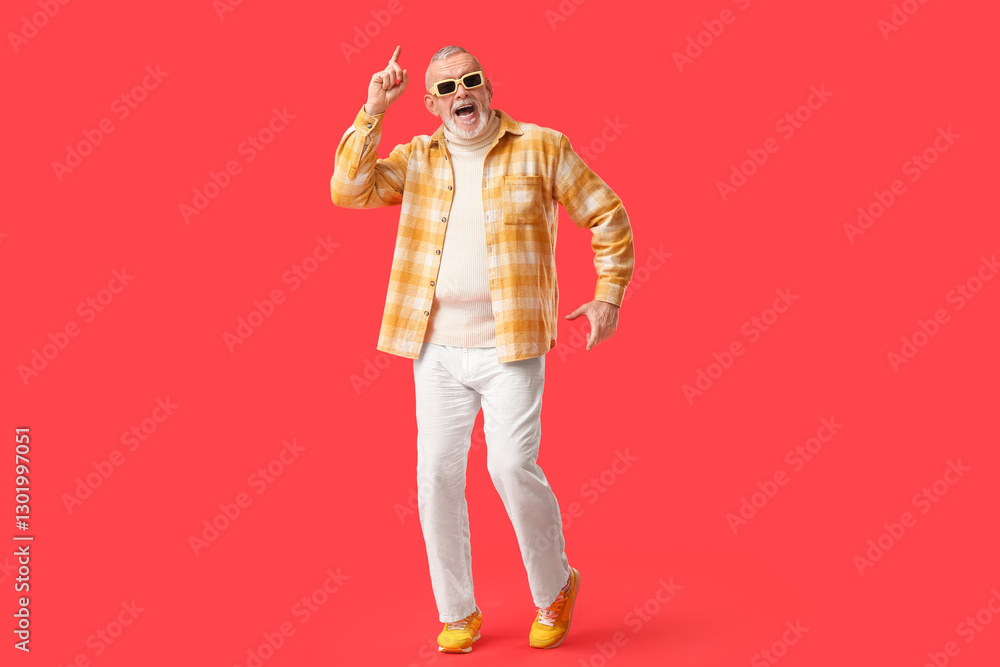 Happy senior man in sunglasses dancing on red background. National Grandpa Day Happy senior man in sunglasses dancing on red background. National Grandpa Day