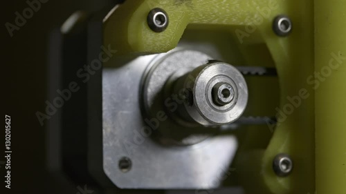 3d printer stepper motor pulley, close up view showing precision technology in use.  Rotating pulley turning x axis belt.