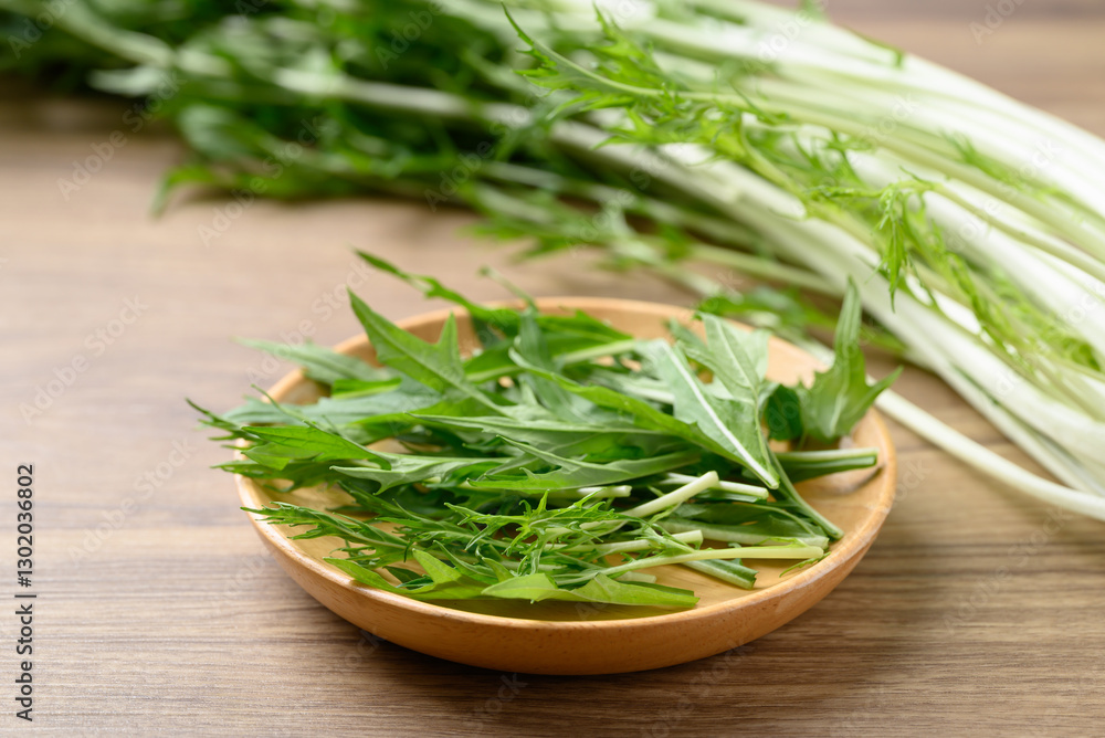 Mizuna, Water green, Japanese mustard green or spider mustard on wooden plate Mizuna, Water green, Japanese mustard green or spider mustard on wooden plate