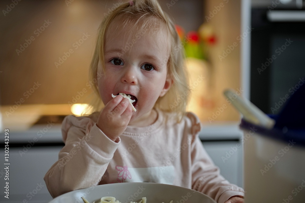 Little girl sitting at the table and eating Little girl sitting at the table and eating