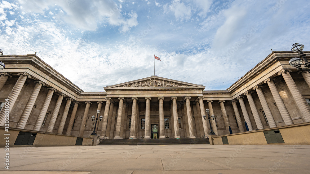 Fototapeta premium A majestic neoclassical façade with iconic columns defines the British Museum in London, emphasizing its historical importance beneath a wide sky.