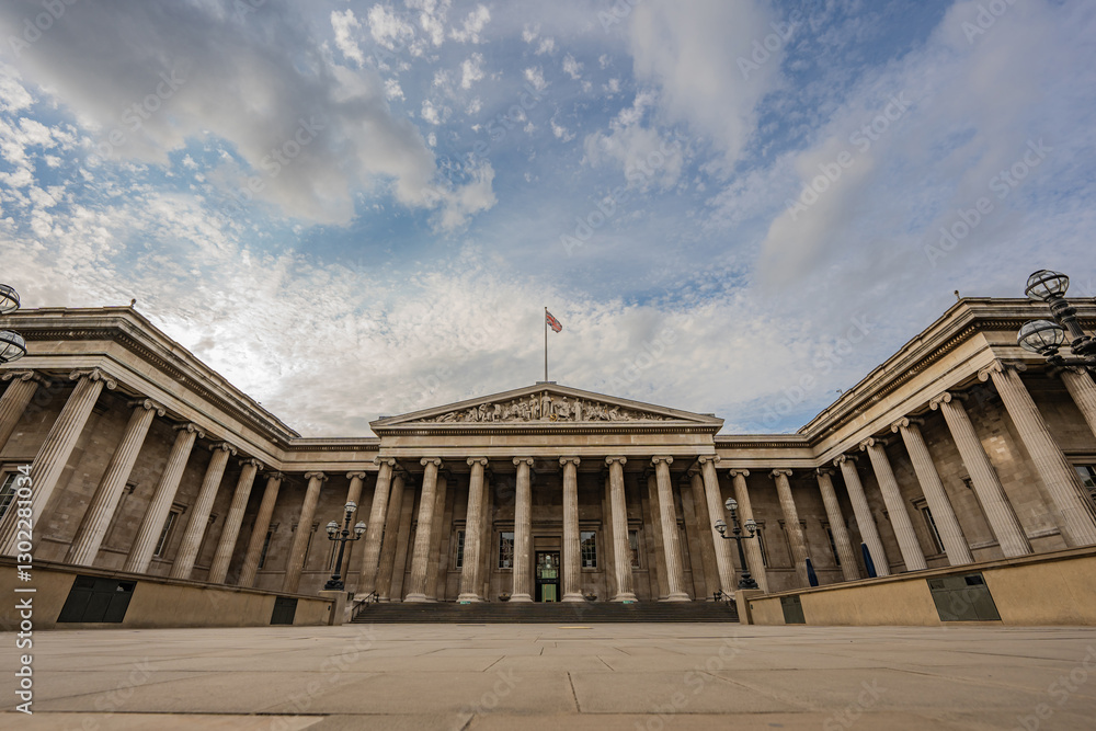 Fototapeta premium The British Museum impressive columns and symmetrical architecture showcase neoclassical design, highlighting its significance against the vast London sky.