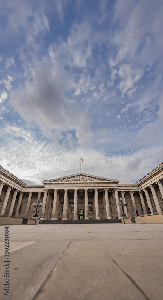 Fototapeta premium Neoclassical facade of the British Museum in London, with its symmetrical columns, emphasizes the museum historic legacy under an open sky.