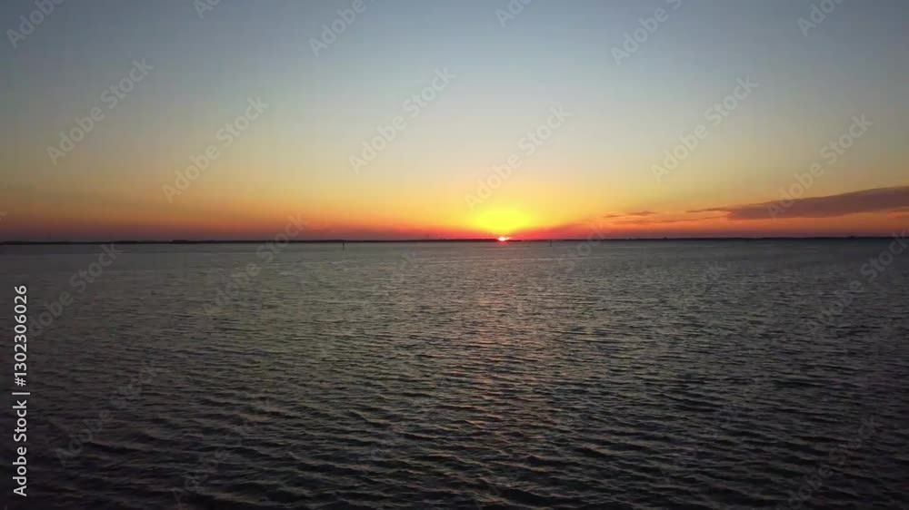 A serene sunset over a vast, rippled ocean