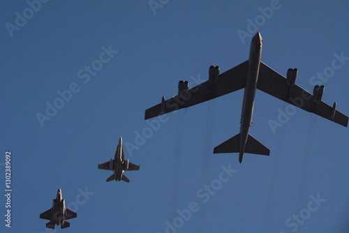 Photography B 52 Stratofortress and fighter jets flying in formation against a clear blue sky