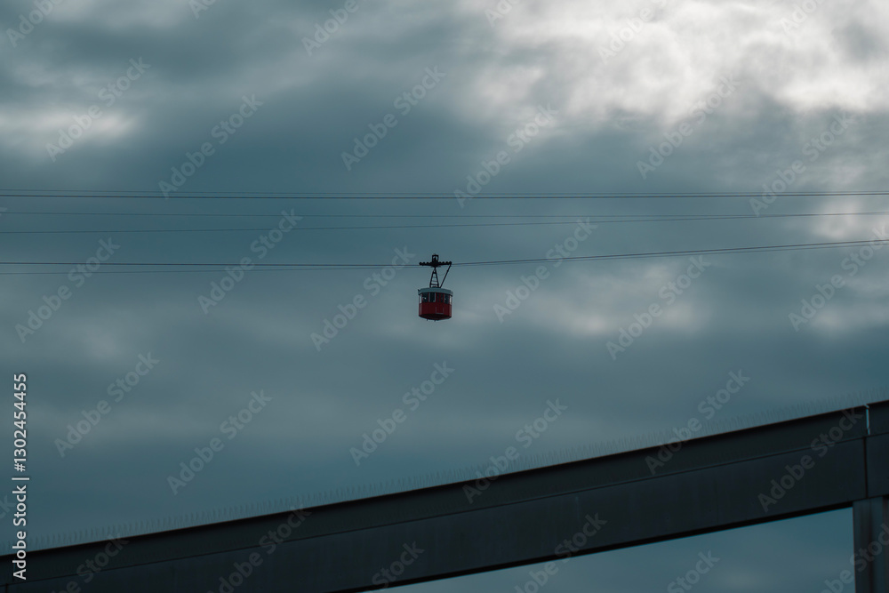 A cable car gondola against the backdrop of the sky, offering a scenic ride through the clouds. A cable car gondola against the backdrop of the sky, offering a scenic ride through the clouds.
