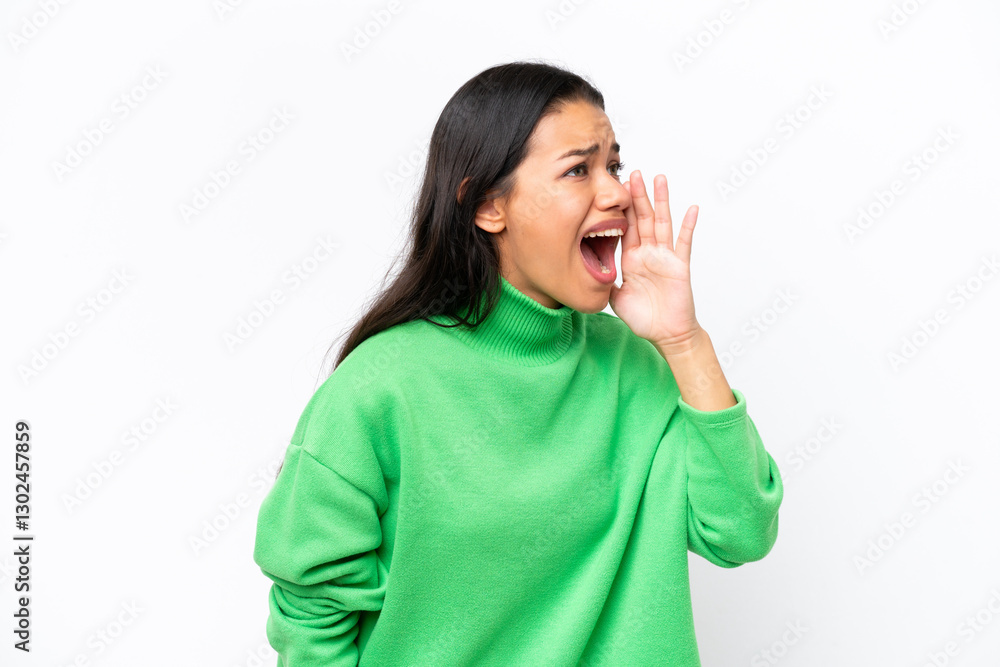 Young Colombian woman isolated on white background shouting with mouth wide open to the side Young Colombian woman isolated on white background shouting with mouth wide open to the side