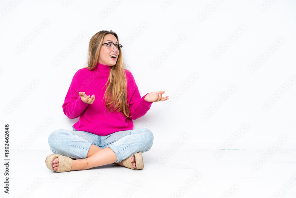 Young caucasian woman sitting on the floor isolated on white background with surprise facial expression Young caucasian woman sitting on the floor isolated on white background with surprise facial expression