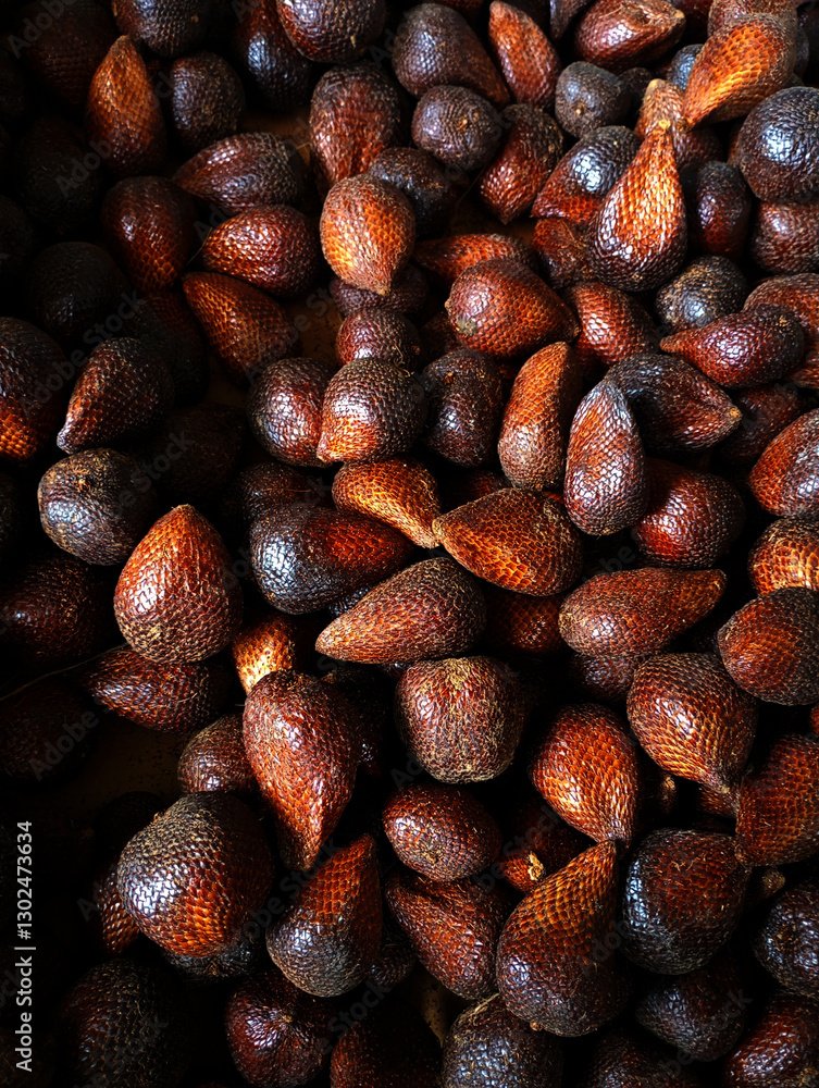 Obraz premium Pile of fresh salak (snake fruit) showcasing their unique scaly skin and earthy tones.