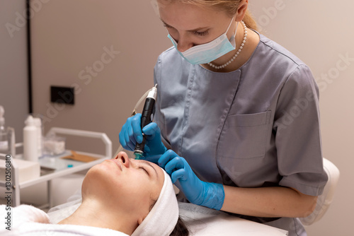 Skincare professional performing microneedling treatment on client in spa setting