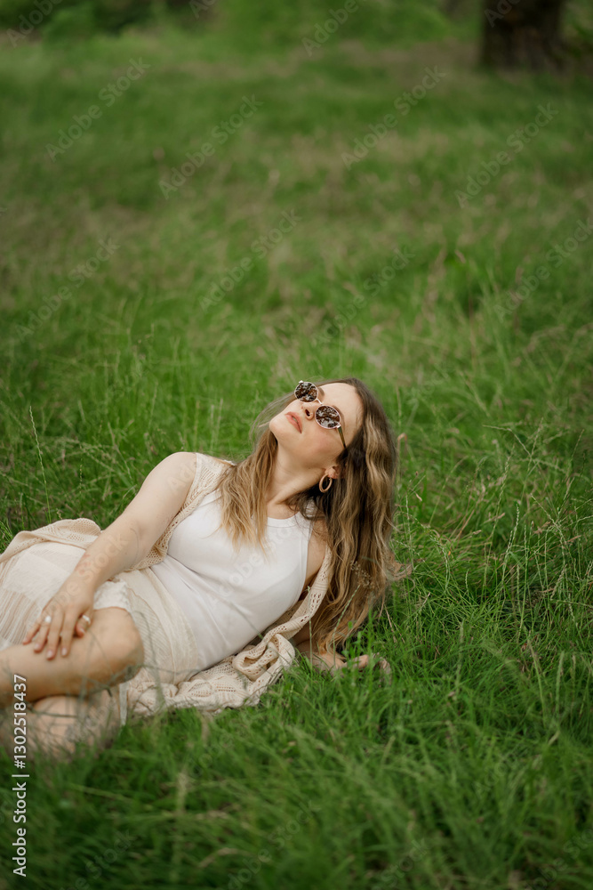 young woman lying on the grass in glasses looking up at the sky young woman lying on the grass in glasses looking up at the sky