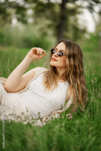 Woman in the garden lying on the grass looking relaxed and happy during summer time