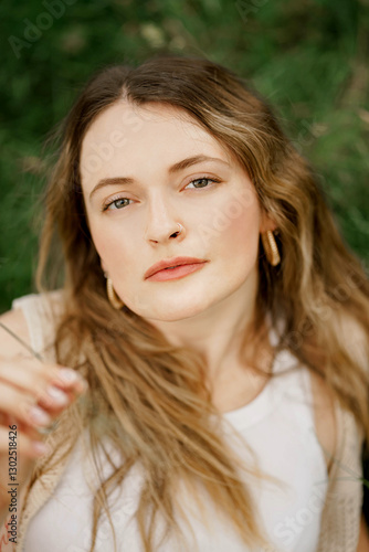 A young girl on a grass in the park with smooth skin looking up and very relaxed 