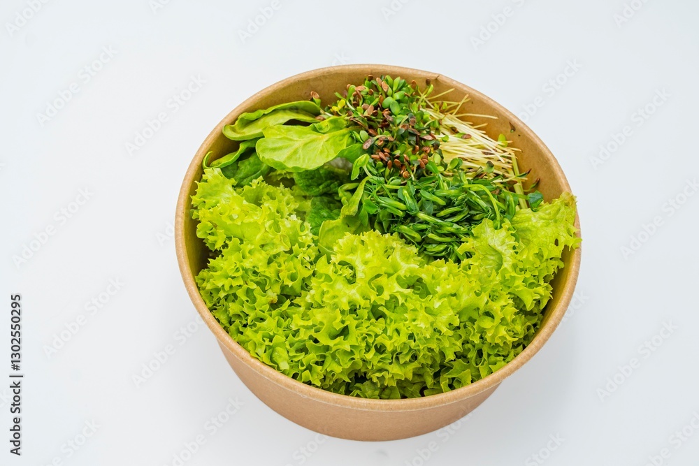 Fresh salad in a bowl on a white background. Close-up of fresh organic green salad with microgreens in a bowl. Healthy food. Fresh salad in a bowl on a white background. Close-up of fresh organic green salad with microgreens in a bowl. Healthy food.