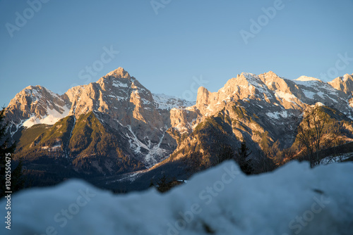 Wallpaper Mural Winter sunset view of the snow-covered Hochkönig mountain range from Maria Alm-Saalfelden am Steinernen Meer, with the peaks lit by soft orange, pink, and purple hues. Torontodigital.ca