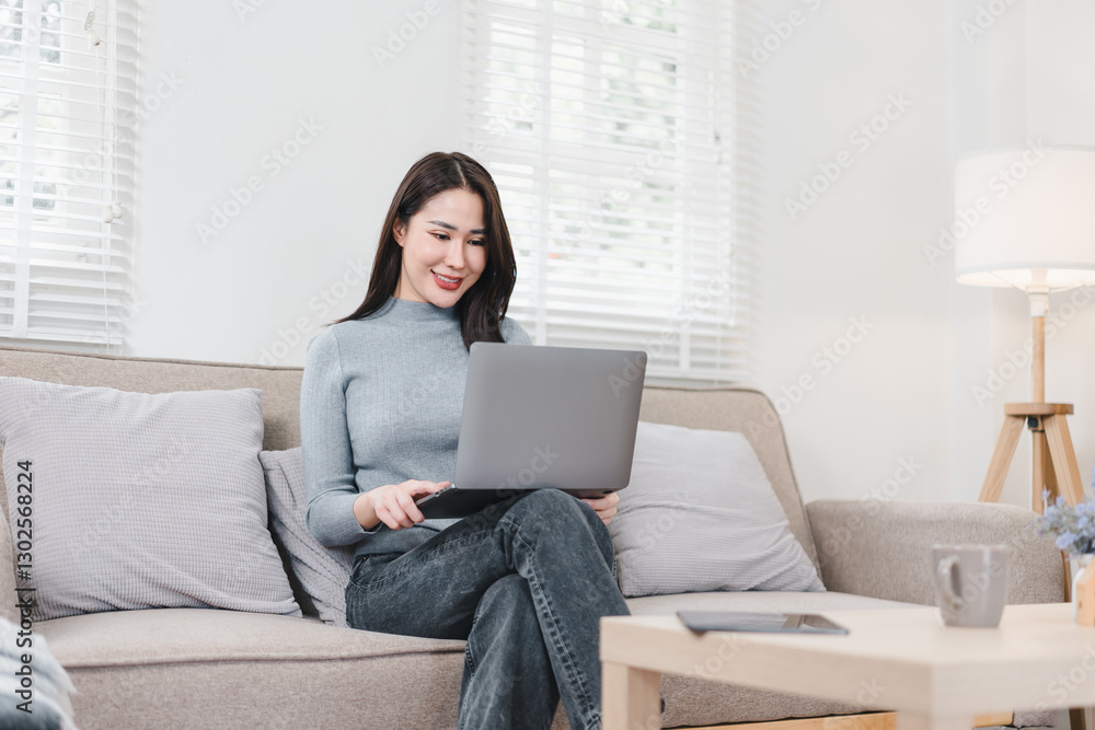 Asian businesswoman working on laptop in bright, modern home office with calm atmosphere. Asian businesswoman working on laptop in bright, modern home office with calm atmosphere.