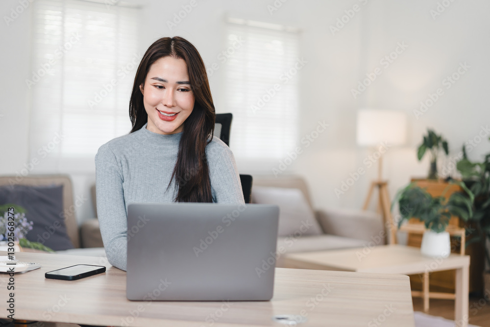 Asian businesswoman working at desk with laptop, writing in notebook, and smiling in bright office. Asian businesswoman working at desk with laptop, writing in notebook, and smiling in bright office.