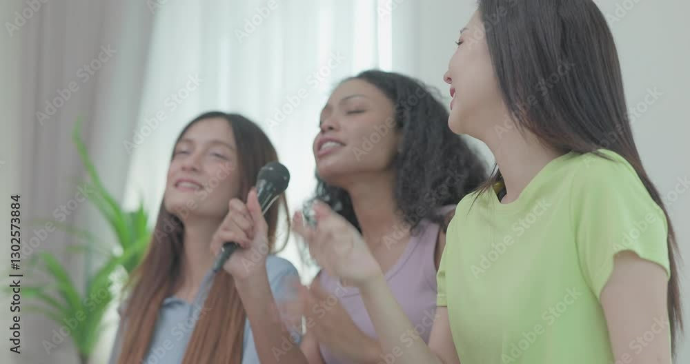 A group of three young multicultural friends singing and enjoying a karaoke session indoors. They are laughing and having fun, creating a joyful and energetic atmosphere.
A group of three young multicultural friends singing and enjoying a karaoke session indoors. They are laughing and having fun, creating a joyful and energetic atmosphere.