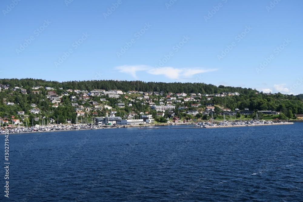 Frogn Drøbak, Akershus, Noway - 07 12 2024: Vom Sonnendeck der Fähre von Oslo nach Kopenhagen ist die Silhouette der Gemeinde Frogn Drøbak am Oslofjord zu sehen. Es ist ein sonniger Sommertag. Frogn Drøbak, Akershus, Noway - 07 12 2024: Vom Sonnendeck der Fähre von Oslo nach Kopenhagen ist die Silhouette der Gemeinde Frogn Drøbak am Oslofjord zu sehen. Es ist ein sonniger Sommertag.