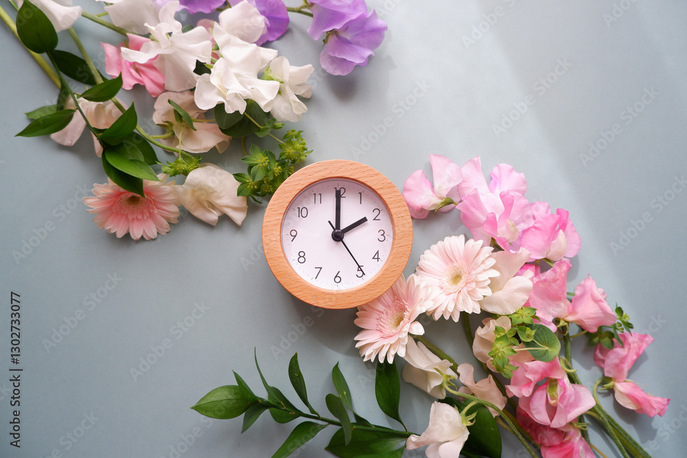 Spring forward background. Beautiful flowers and a clock composition on pastel color background. Spring image and floral background.