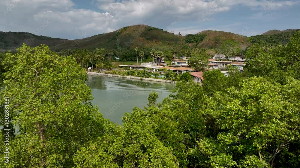 Tropical beachfront villas overlooking a turquoise bay surrounded by lush green hills and calm sea waters. Koh Yao Yai, Thailand Tropical beachfront villas overlooking a turquoise bay surrounded by lush green hills and calm sea waters. Koh Yao Yai, Thailand