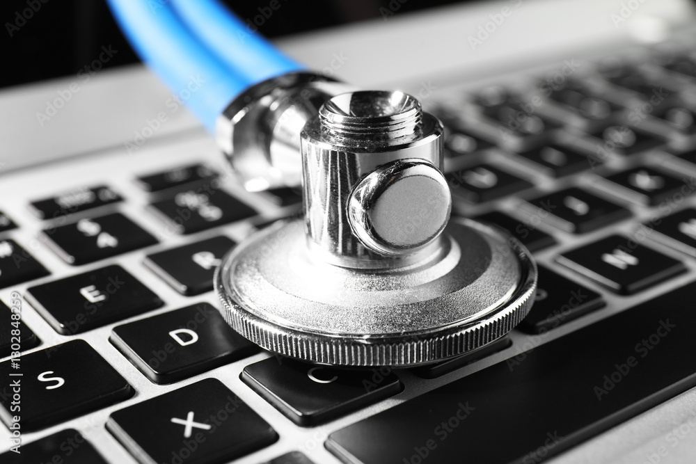 Technical support concept. Stethoscope on laptop keyboard, closeup