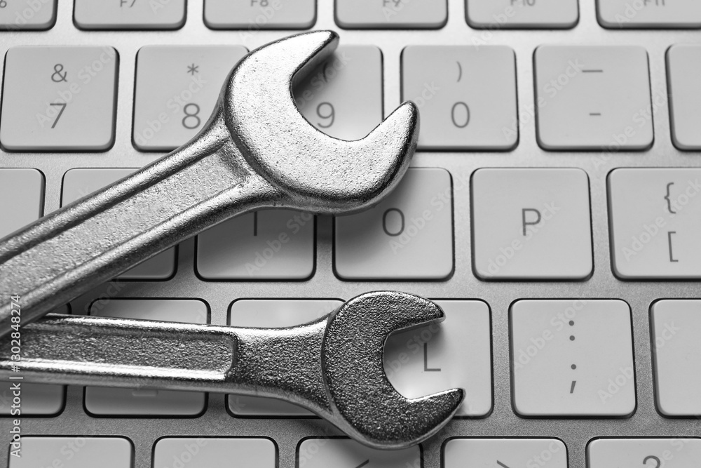 Fototapeta premium Technical support concept. Wrenches on keyboard, top view