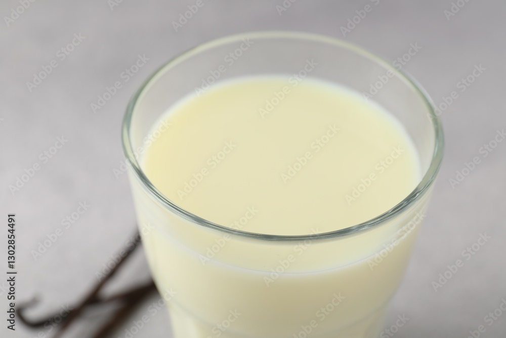 Delicious vanilla milk in glass on grey table, closeup Delicious vanilla milk in glass on grey table, closeup