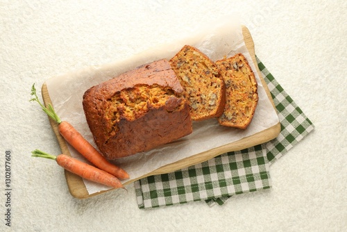 Homemade carrot cake with nuts and vegetables on white textured table, top view