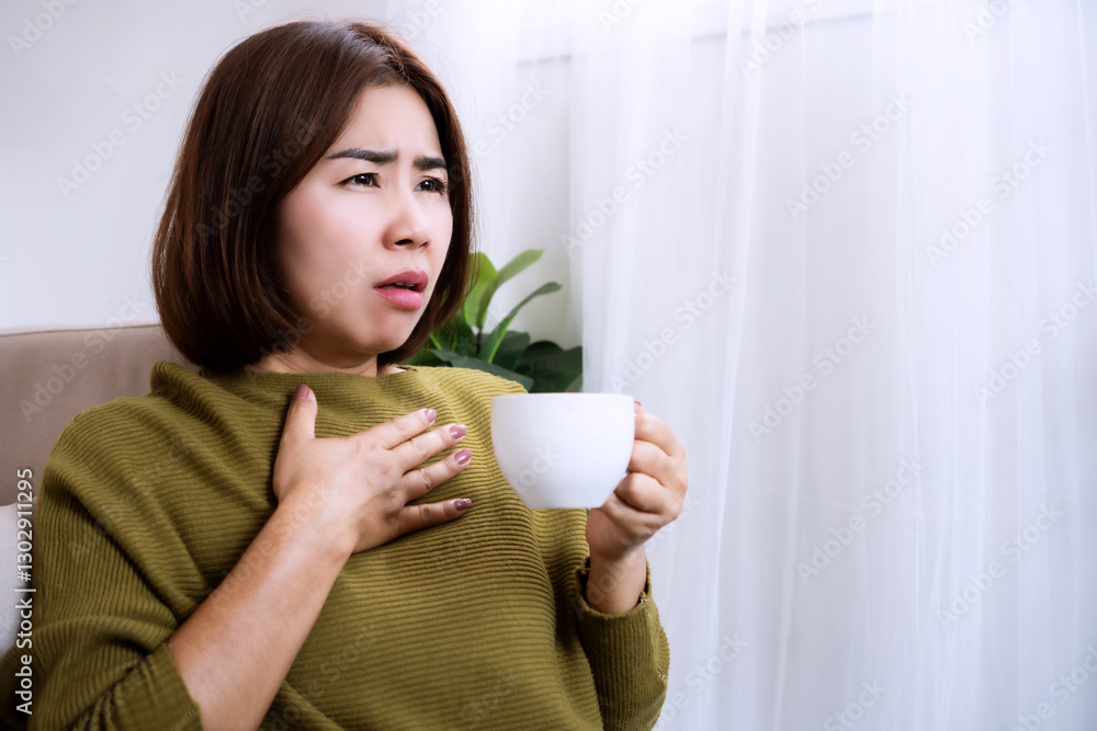 Asian woman experiencing faster heartbeat after drinking coffee, caused by effects of caffeine on heart rate and energy levels or warning sign of heart health Asian woman experiencing faster heartbeat after drinking coffee, caused by effects of caffeine on heart rate and energy levels or warning sign of heart health