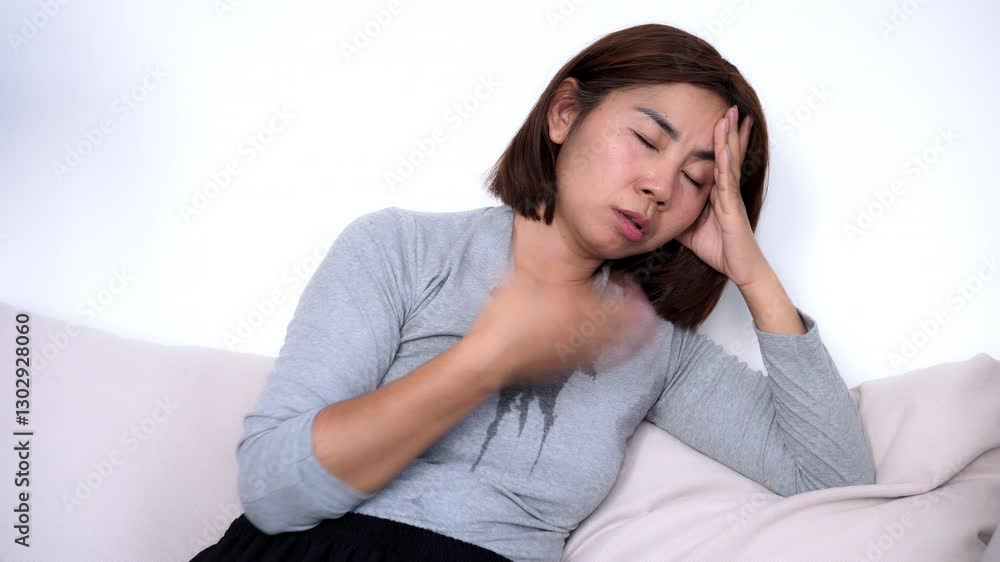 sweating Asian woman with a wet shirt feeling dizzy and lightheaded, nearly fainting due to hot summer weather or menopause-related symptoms sweating Asian woman with a wet shirt feeling dizzy and lightheaded, nearly fainting due to hot summer weather or menopause-related symptoms