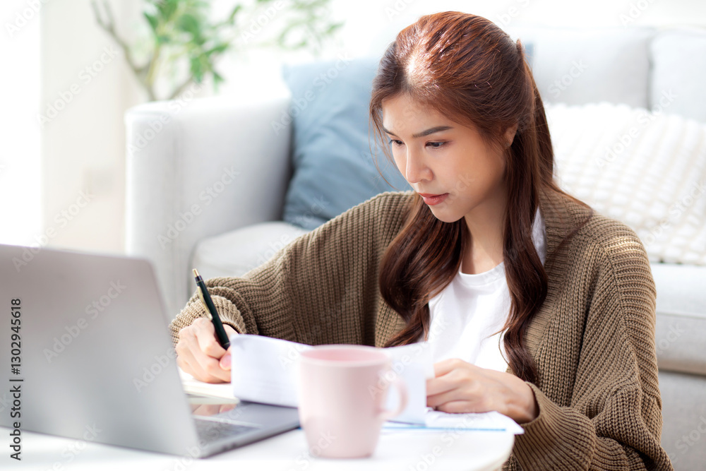 Young asian woman calculates bills and cost for planning finance, woman looking expense with burden or investment and writing on paperwork, statement banking and debt for loan, business and financial. Young asian woman calculates bills and cost for planning finance, woman looking expense with burden or investment and writing on paperwork, statement banking and debt for loan, business and financial.