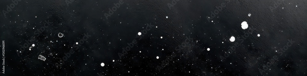 Fototapeta premium Black canvas with irregular white paint splatters; high contrast, dynamic, impact