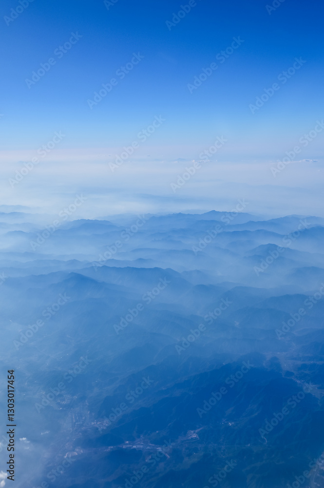The view of the stunning landscape with mountains and clouds from the airplane window. Aerial view of the natural scene, mountain range. Travel and landscape scene. Travel and nature concept. The view of the stunning landscape with mountains and clouds from the airplane window. Aerial view of the natural scene, mountain range. Travel and landscape scene. Travel and nature concept.