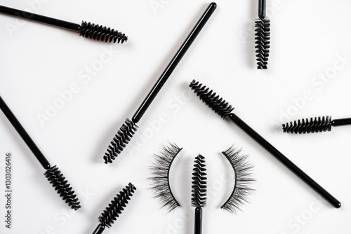 Scattered eyelash and brow makeup brushes with false eyelashes on white background. Women beauty and eye makeup.