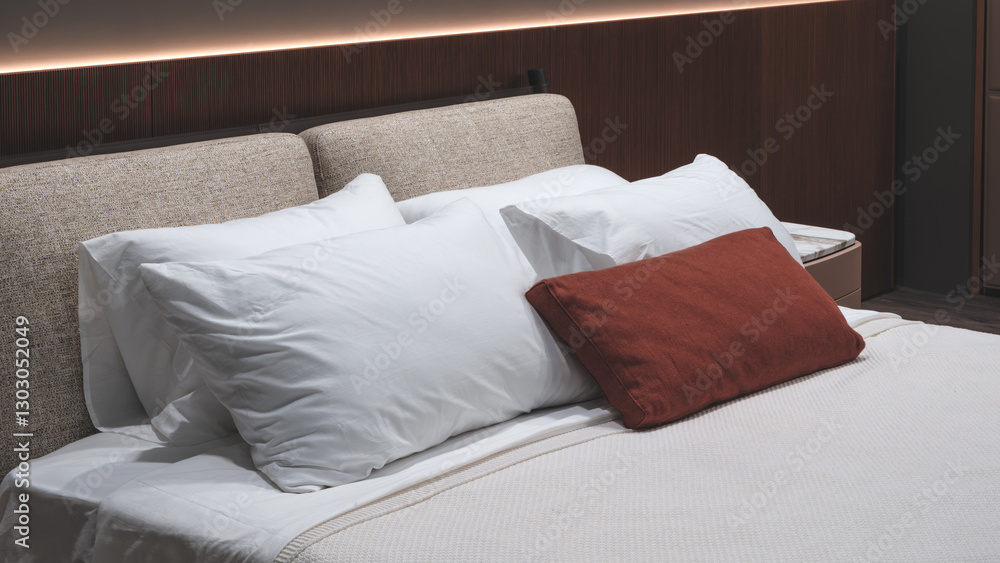 A bed with two white pillows and a red pillow. The bed is made and the pillows are neatly arranged. The bed is in a room with a wooden wall A bed with two white pillows and a red pillow. The bed is made and the pillows are neatly arranged. The bed is in a room with a wooden wall