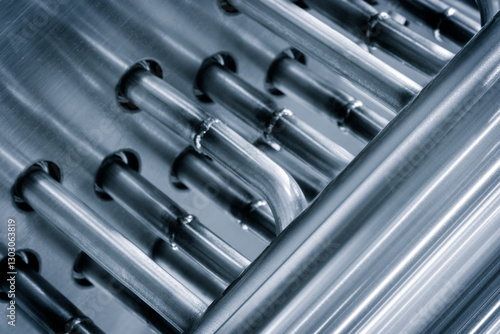Close up of metal tubes with silver handle. The tube is curved and twisted, giving it a unique and interesting look. Industrial cooler concept abstract background