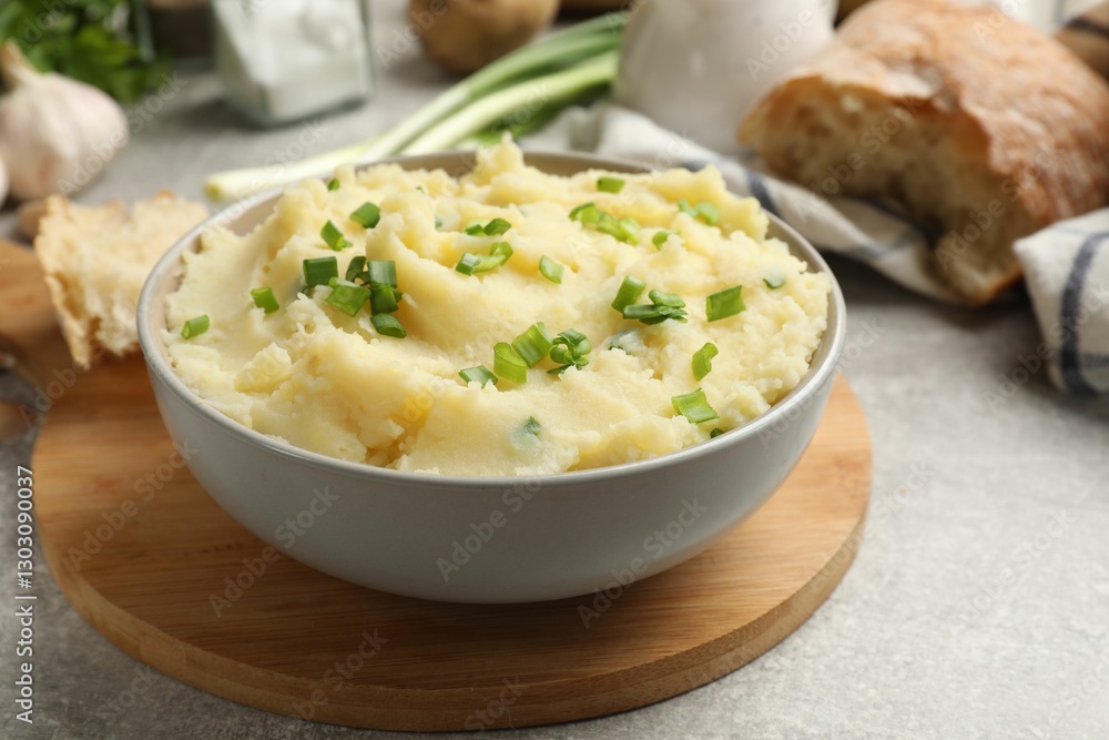 Delicious mashed potato with green onions served on grey table, closeup Delicious mashed potato with green onions served on grey table, closeup