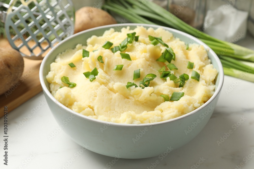 Delicious mashed potato with green onions in bowl on white marble table, closeup Delicious mashed potato with green onions in bowl on white marble table, closeup