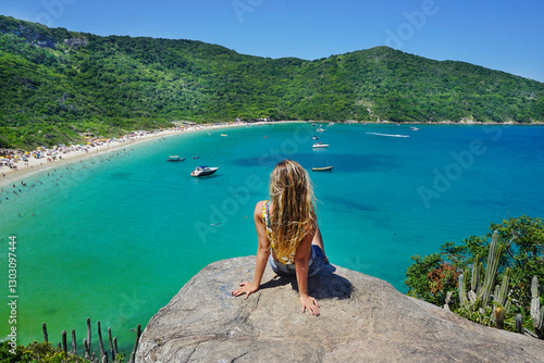 Beautiful woman contemplating the beauty of the Forno Beach, and its crystal clear waters. Arraial do Cabo City, RJ, Brazil, Feb 2020