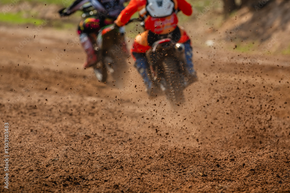 Selective focus details of debris in a motocross race.Professional motocross rider creates a huge cloud of dust.Enduro bike rider on action, dirt ride and muddy road.Motocross extreme sport. Selective focus details of debris in a motocross race.Professional motocross rider creates a huge cloud of dust.Enduro bike rider on action, dirt ride and muddy road.Motocross extreme sport.