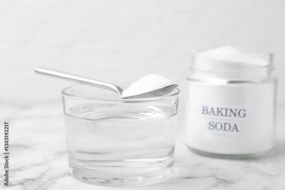 Glass of water and baking soda on white marble table, selective focus Glass of water and baking soda on white marble table, selective focus