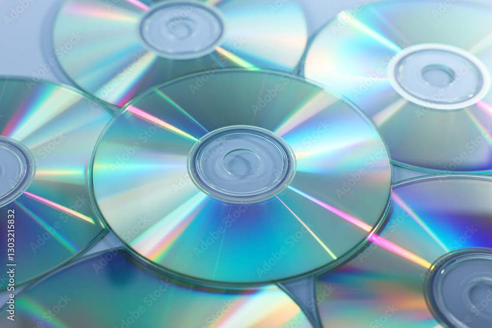 Many shiny compact discs on dusty blue background, closeup Many shiny compact discs on dusty blue background, closeup