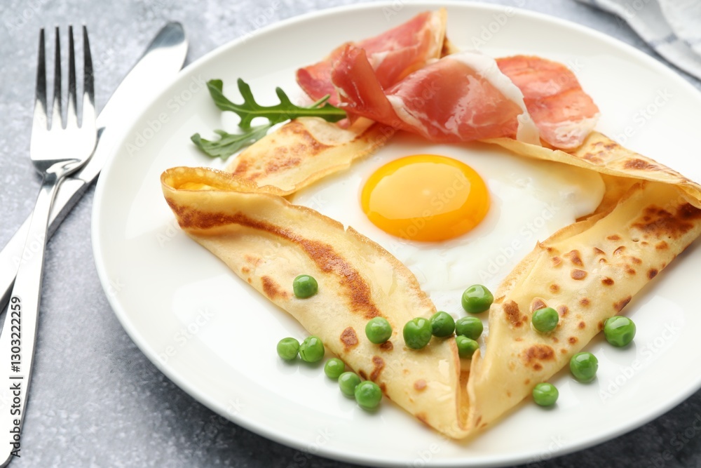Delicious crepe with egg, bacon, arugula and green peas on grey table, closeup Delicious crepe with egg, bacon, arugula and green peas on grey table, closeup