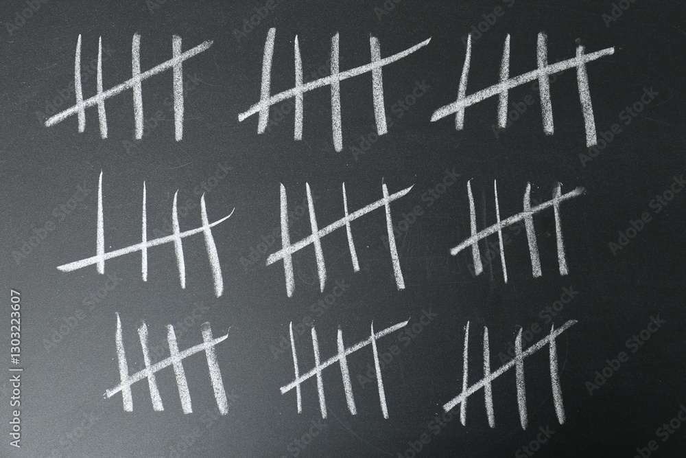 Counting days by drawing sticks with chalk on blackboard, closeup Counting days by drawing sticks with chalk on blackboard, closeup