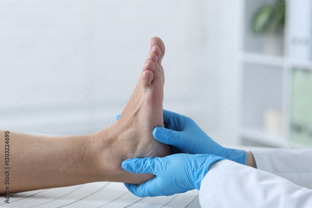 Fototapeta premium Doctor examining patient's foot in hospital, closeup