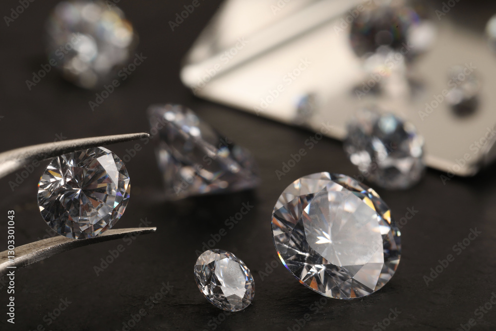 Tweezers with beautiful gemstones on black table, selective focus Tweezers with beautiful gemstones on black table, selective focus