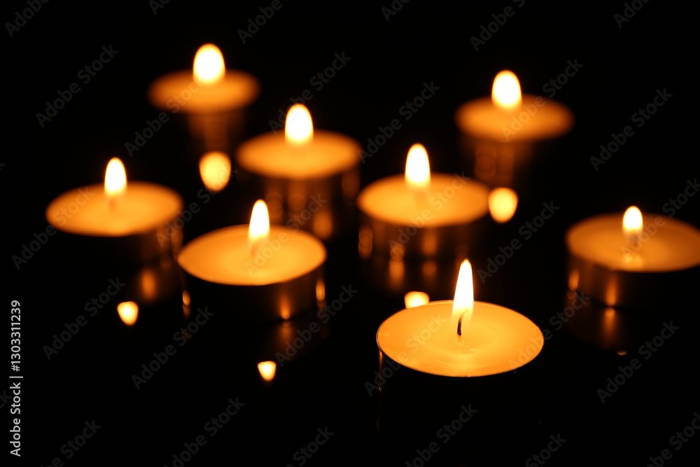 Many burning candles on dark background, closeup Many burning candles on dark background, closeup