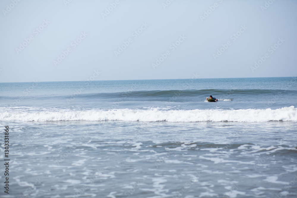 A man on a vacation surfs on a board in the ocean A man on a vacation surfs on a board in the ocean