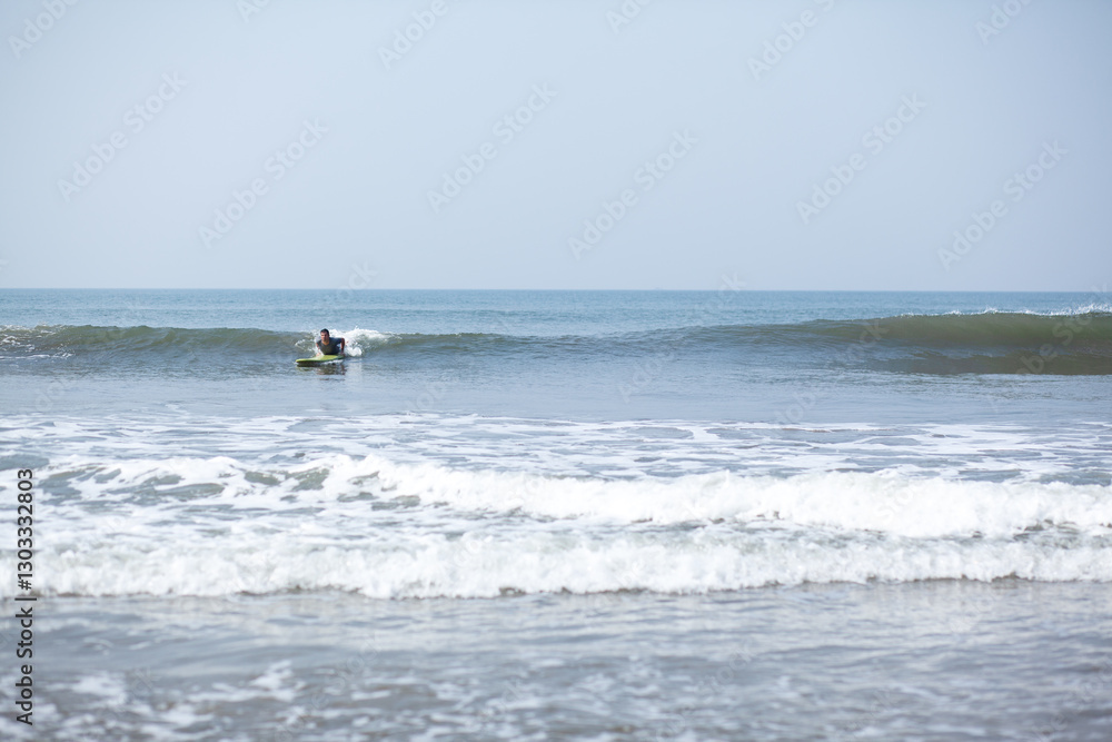 A man on a vacation surfs on a board in the ocean A man on a vacation surfs on a board in the ocean